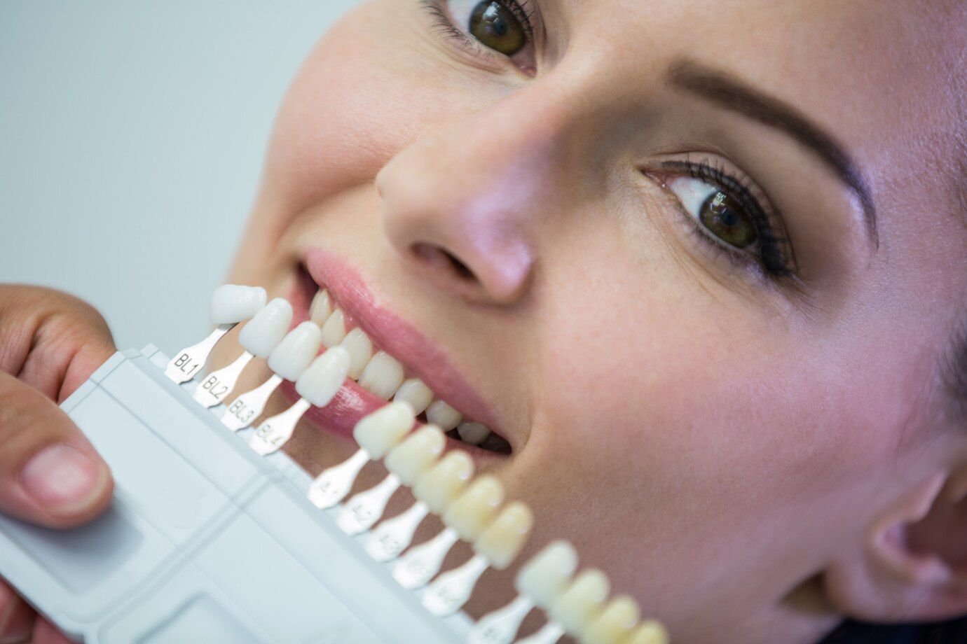 dentist-examining-female-patient-with-teeth-shades 107420-74180