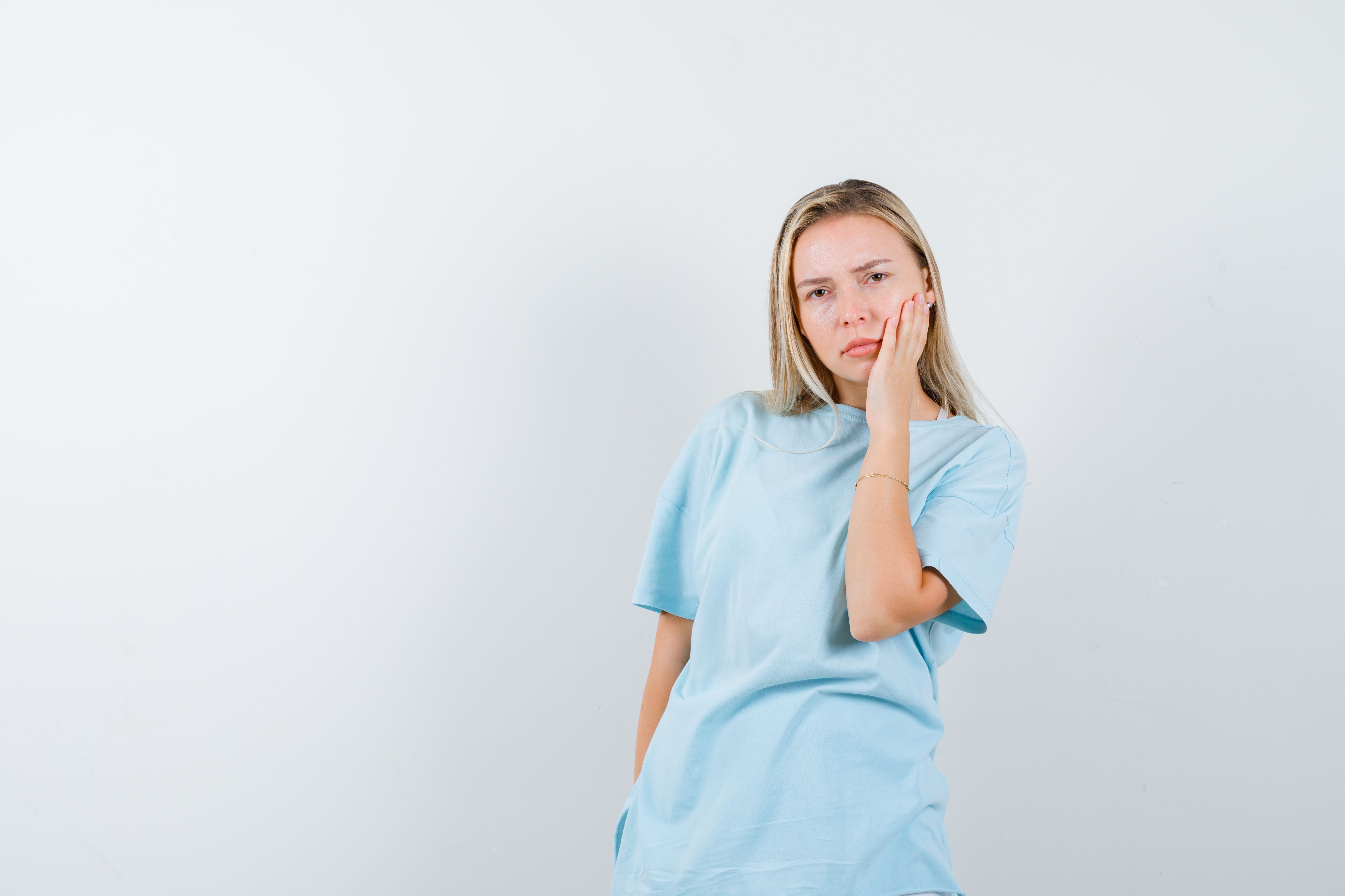 young-lady-holding-hand-cheek-t-shirt-looking-thoughtful-isolated